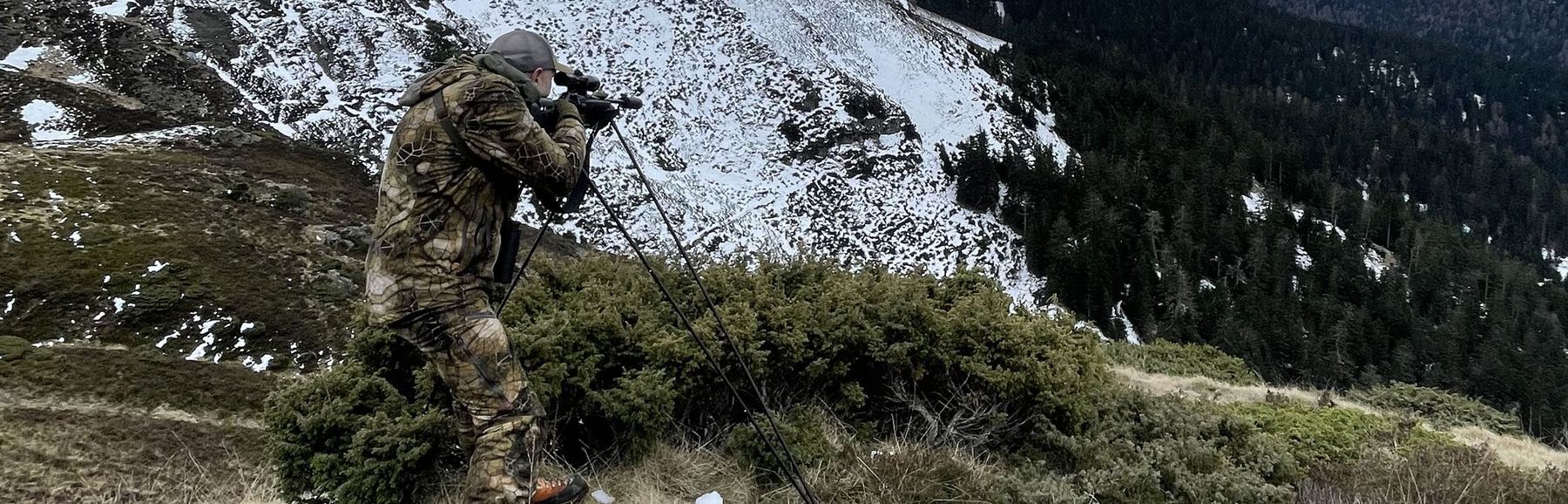 Chasseur en position de tir sur bâtons, face à la montagne enneigée