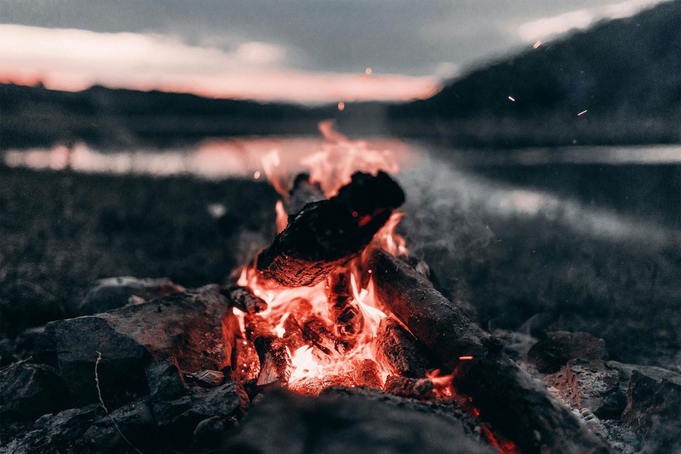 Feu de camp au bord de l'eau, à l'heure bleue